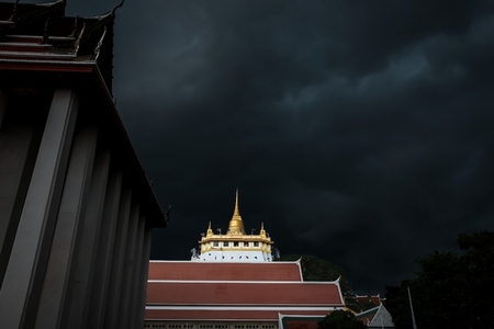 Golden mountain in Wat Saket Bangkok Thailand covered with dark