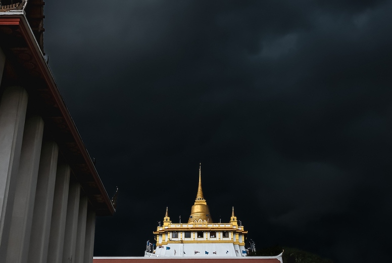Golden mountain in Wat Saket Bangkok Thailand covered with dark