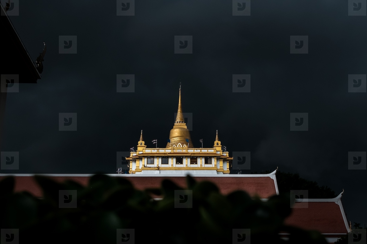 Golden mountain in Wat Saket Bangkok Thailand covered with dark