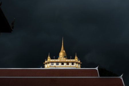 Golden mountain in Wat Saket Bangkok Thailand covered with dark