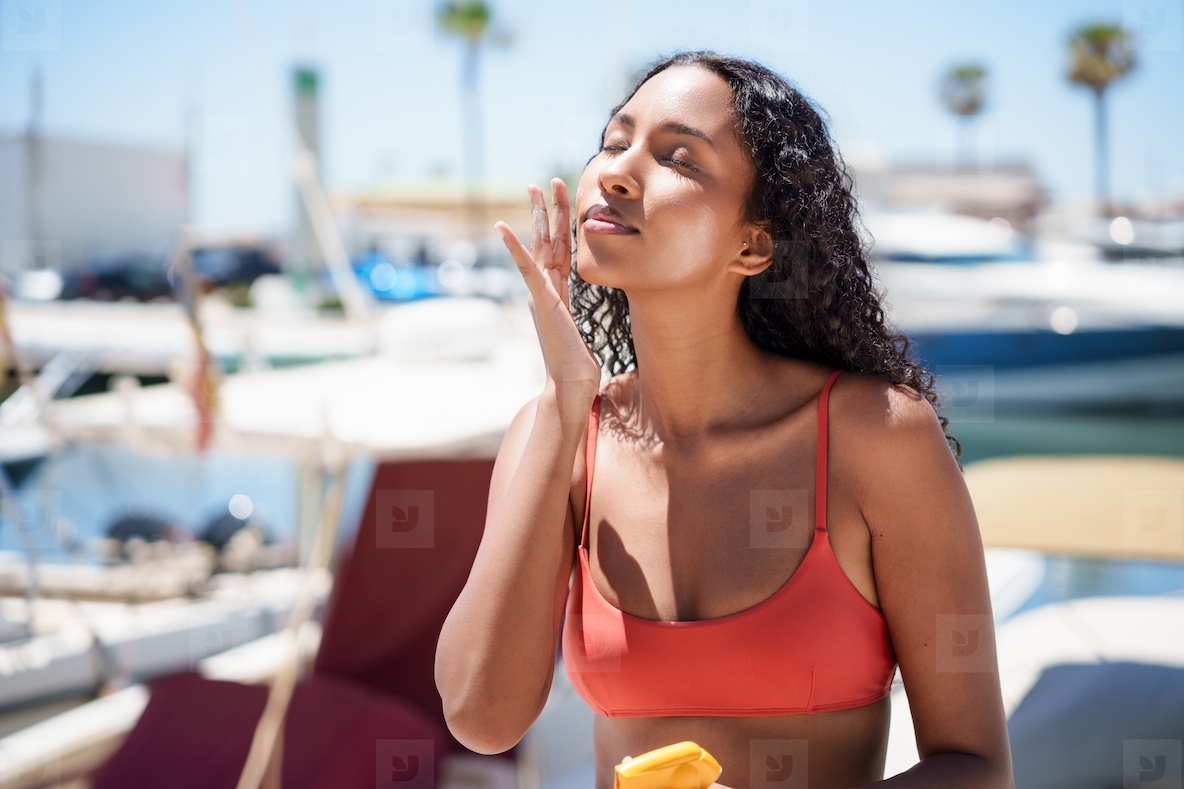Spending a beautiful and enjoyable sunny day by the water applies sunscreen