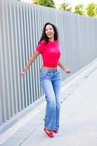 A Joyful Woman Dancing in a Vibrant and Colorful Outfit on a Bustling City Street A Joyful Woman Dancing in a Vibrant and Colorful Outfit on a Bustling City Street