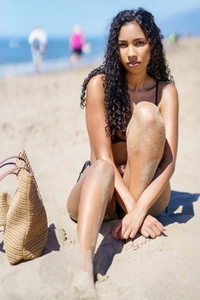 A Young Woman is Relaxing on the Beach  enjoying the sun and the beautiful surroundings