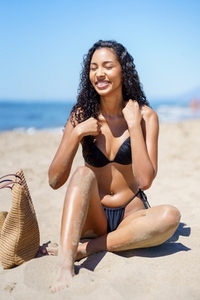 A Young Woman is Fully Enjoying a Beautiful Day at the Beach Under Vibrant Sunshine Today
