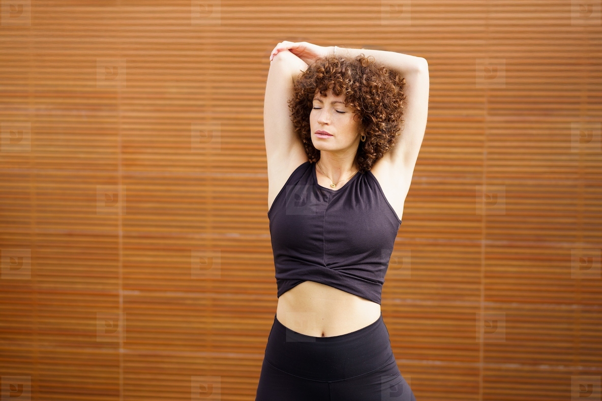 Elegance in Motion A Woman Gracefully Stretching While Dressed in Stylish Athletic Wear