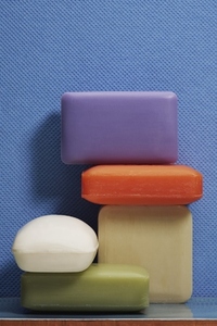 Still life variety of colorful homemade soap bars against textured blue background Still life variety of colorful homemade soap bars against textured blue background