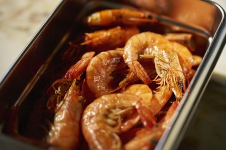 Close up still life shot of cooked prawns in stainless steel container
