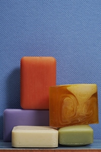 Still life of colorful homemade soap bars on textured blue background
