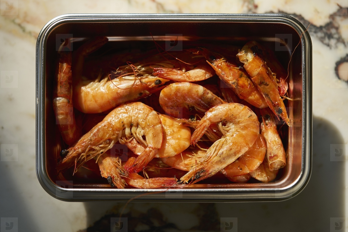 Still life view from above of cooked prawns in stainless steel container