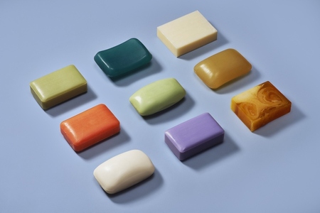 Flat lay still life of multicolored homemade soap on blue background