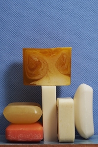 Still life variety of homemade soap bars against textured blue background