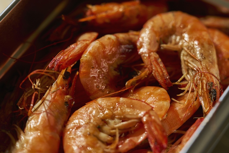 Still life high angle view container of cooked prawns