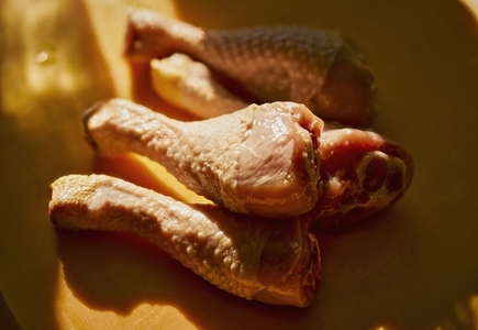 Still life close up sunlight over raw chicken legs in bowl