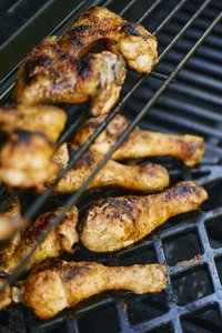 High angle view of grilled chicken drumsticks on barbecue grill