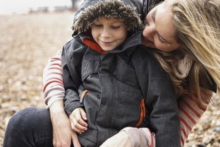 Happy mother and son in warm jacket on winter beach Happy mother and son in warm jacket on winter beach
