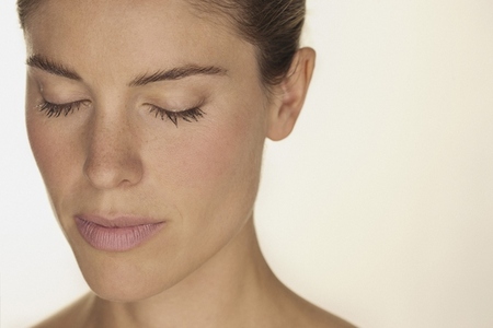 Close up portrait of beautiful serene woman with freckles and eyes closed against white background 01