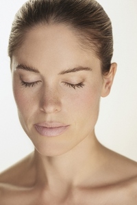 Close up portrait of beautiful serene woman with freckles and eyes closed against white background 02