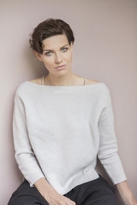 Studio portrait of beautiful woman with short brown hair wearing off shoulder sweater