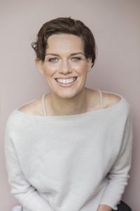 Portrait of happy smiling woman with short brown hair wearing off shoulder sweater