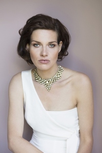 Studio portrait of confident elegant woman in fashionable white dress and necklace