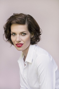 Studio portrait of beautiful young woman with blue eyes and short brown hair
