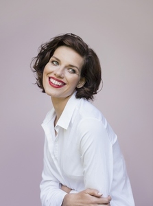 Studio portrait of beautiful brunette woman in red lipstick smiling
