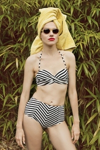 Portrait of stylish woman in striped bikini and sunglasses with hair wrapped in a towel