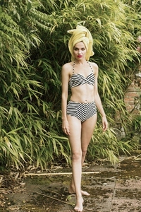 Portrait of beautiful tall woman in striped bikini with hair wrapped in a towel