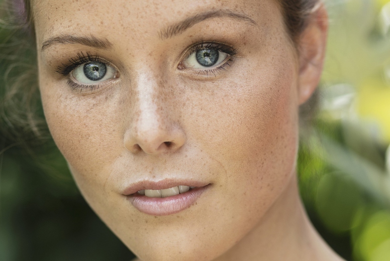 Close up portrait of beautiful young woman with bare shoulders