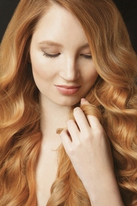 Close up portrait of beautiful young woman with hand in long