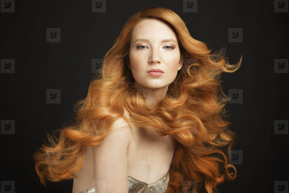 Portrait of beautiful young redhead woman with curly