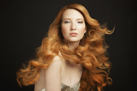 Portrait of beautiful young redhead woman with curly