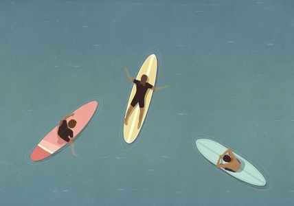 View from above of surfers laying on surfboards in ocean