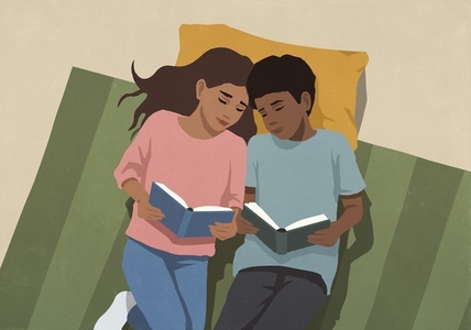 View from above of affectionate mother and son reading books side by side on floor