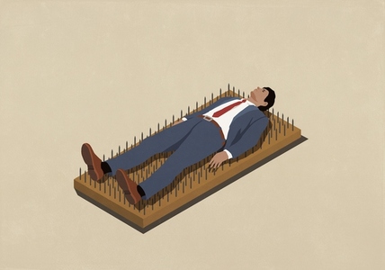 Businessman laying on bed of nails against beige background Businessman laying on bed of nails against beige background