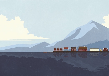 Houses in a row at waterfront along blue lake below mountain