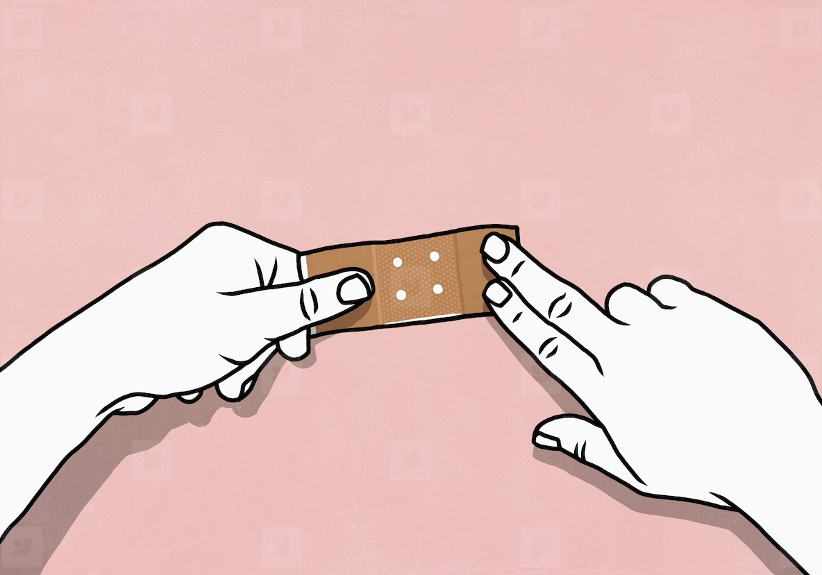 Point of view from above of hands placing bandage on pink background