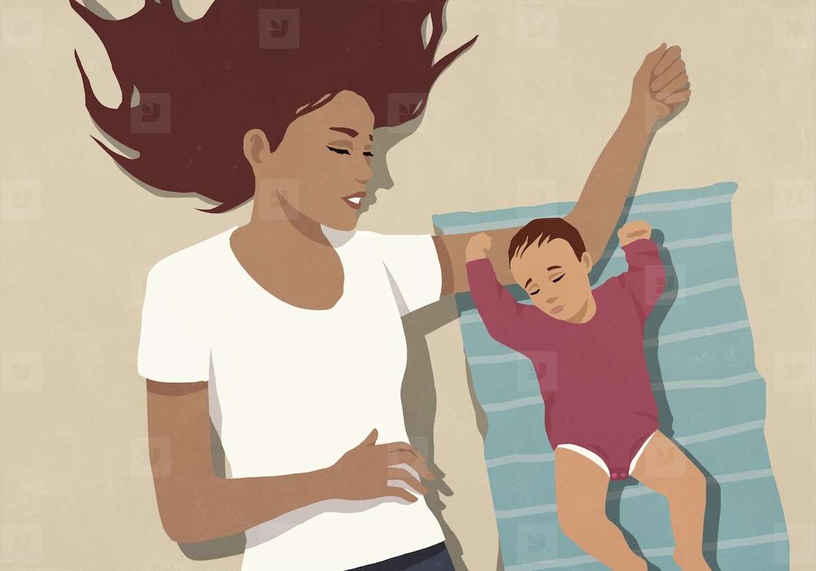 View from above of mother laying next to baby daughter and watching her sleep