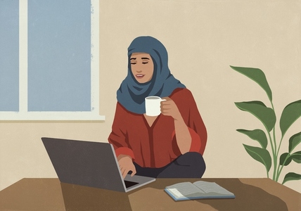 Muslim woman in hijab drinking coffee and working at laptop