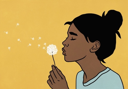 Girl with hair bun closing eyes and making a wish with dandelion against yellow background Girl with hair bun closing eyes and making a wish with dandelion against yellow background