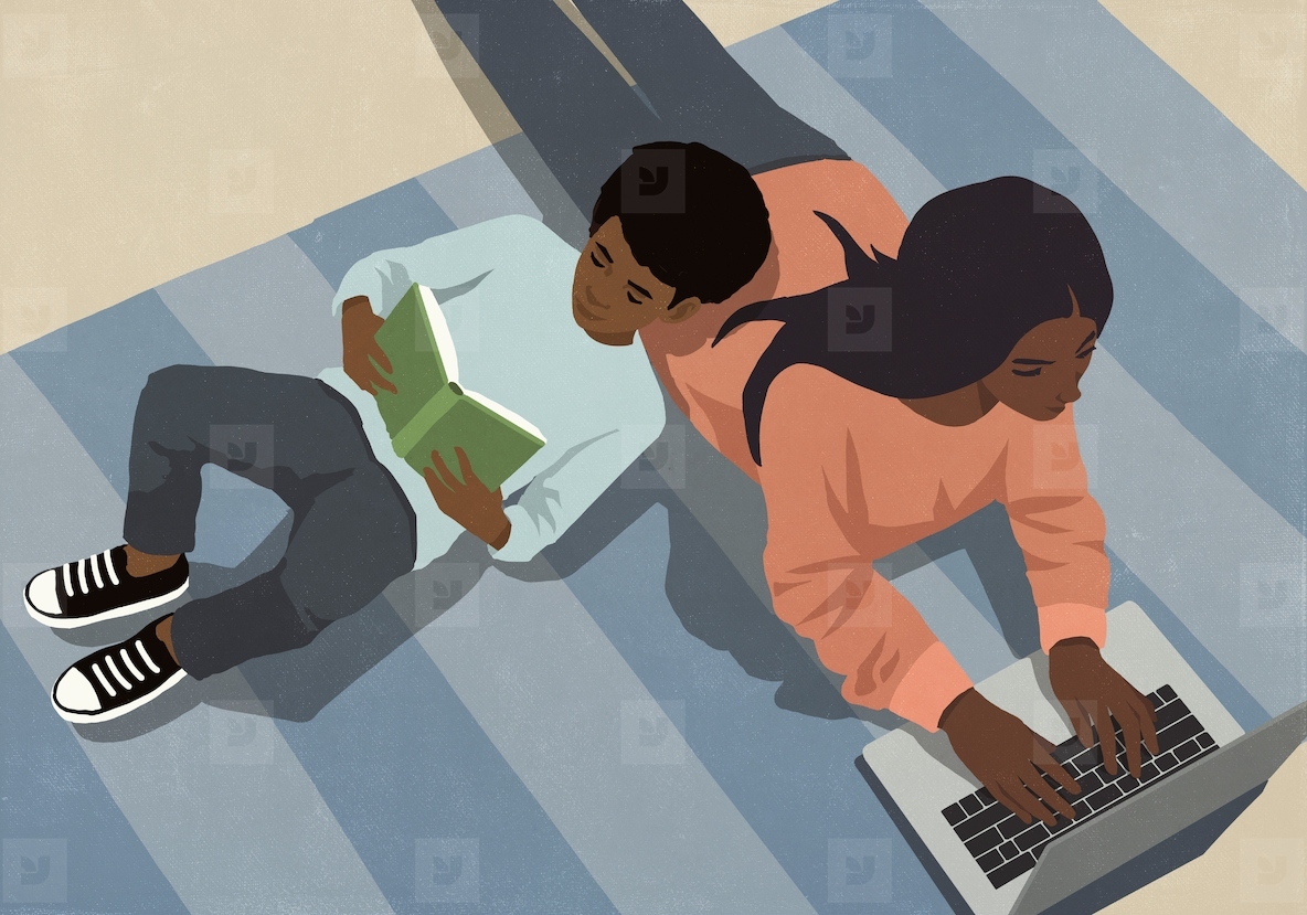 View from above son reading book leaning on mother working at laptop on rug