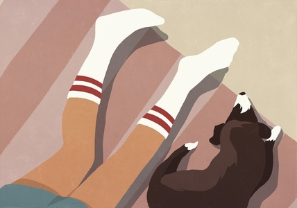 View from above of dog laying on floor next to boy039 s legs