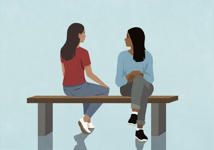 Women friends sitting on bench and talking against blue background