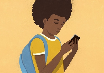 School girl with backpack using smart phone against yellow background