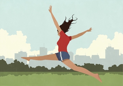 Carefree young woman jumping with arms and legs outstretched in sunny city park