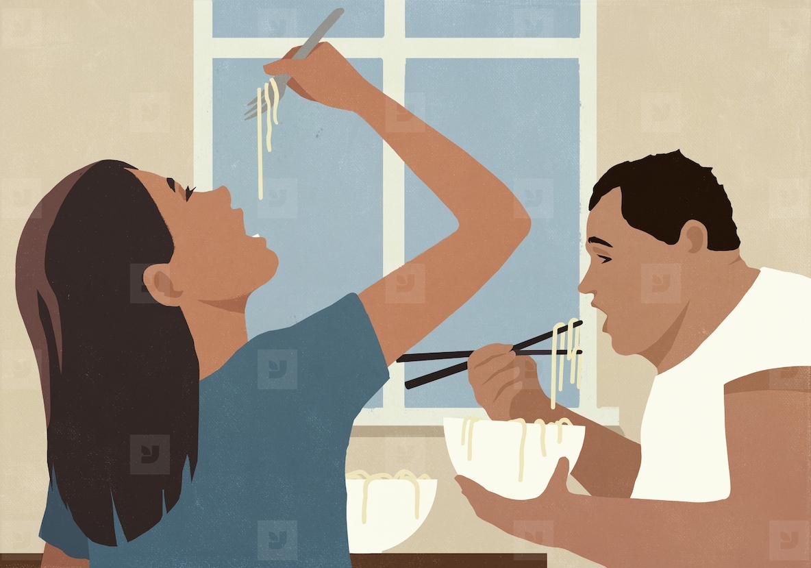 Couple eating pho noodles from bowls with fork and chopsticks at home