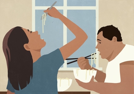 Couple eating pho noodles from bowls with fork and chopsticks at home