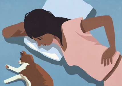 View from above of woman laying in bed watching cat sleeping