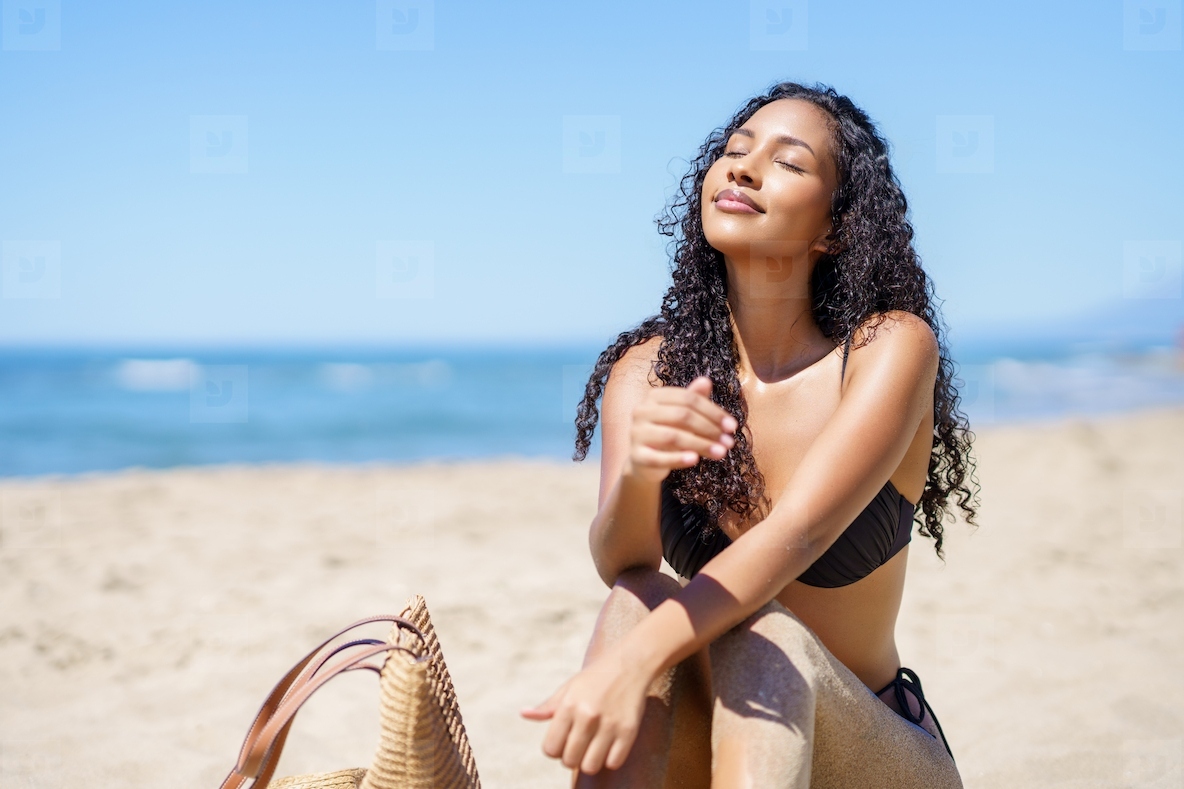 A Young Woman Happily Enjoying a Beautiful Sunny Day at the Beach with Total Bliss