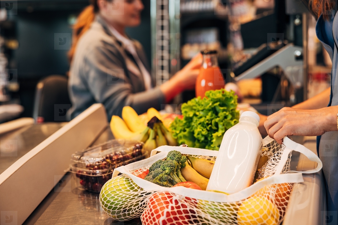 Close up of a string bag full of groceries at counter in store